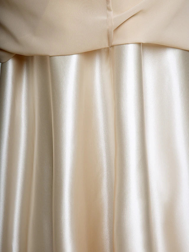 Detail of the flowing chiffon fabric on the skirt of the dark blue Mother of the Bride dress.