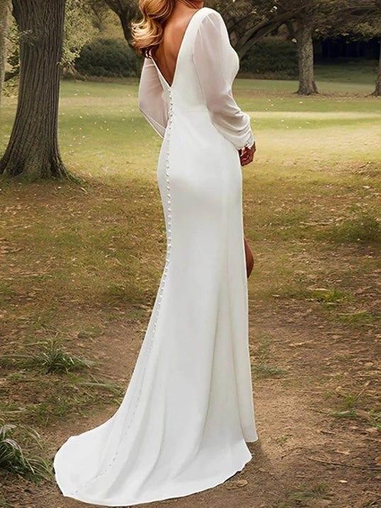 Side view of a bride in a flowing chiffon wedding dress, highlighting the split.