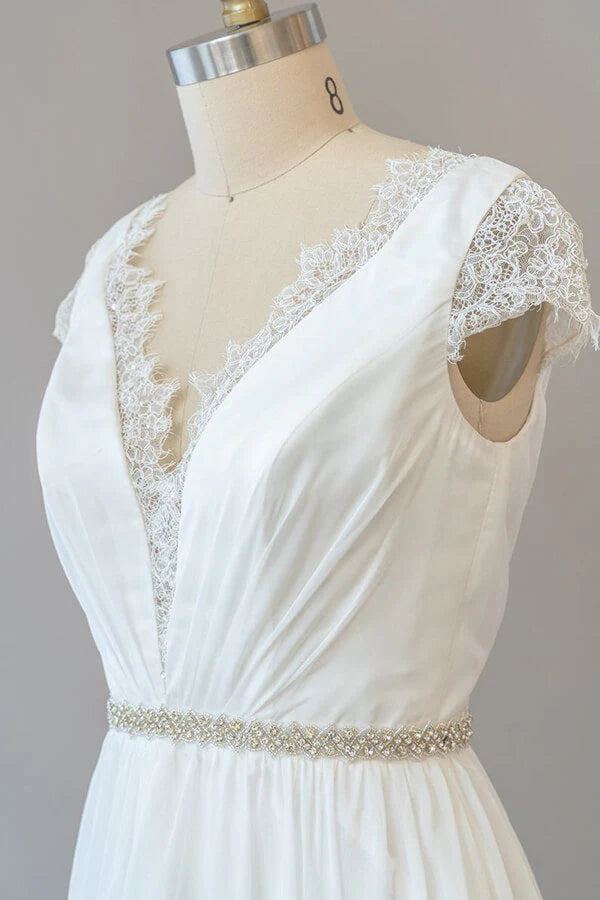 Bride wearing long sheath wedding dress with cap sleeves.