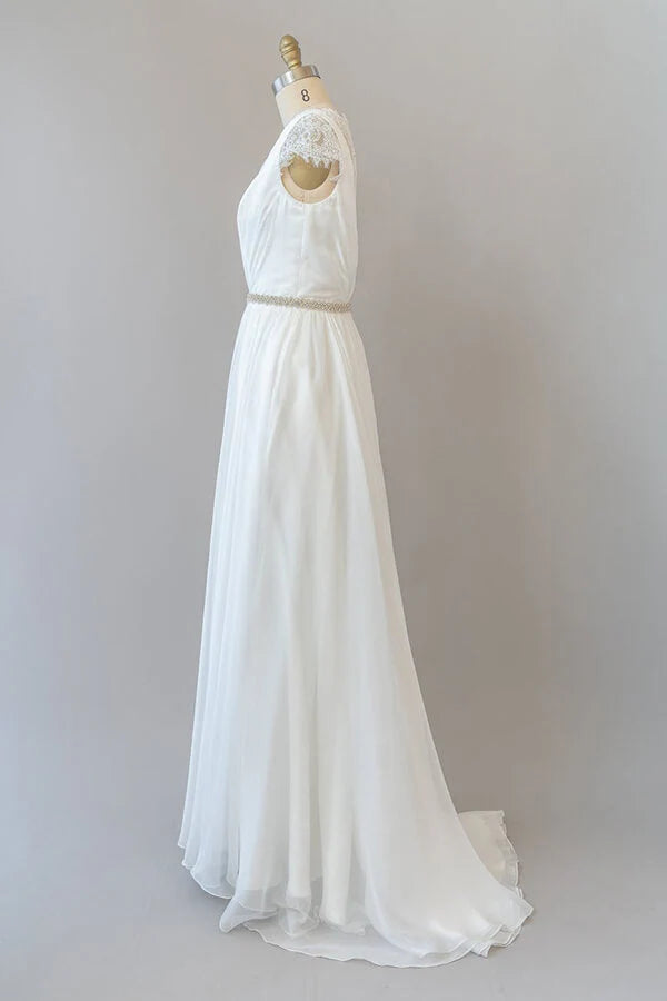 Side view of a bride in a lace and chiffon wedding dress.