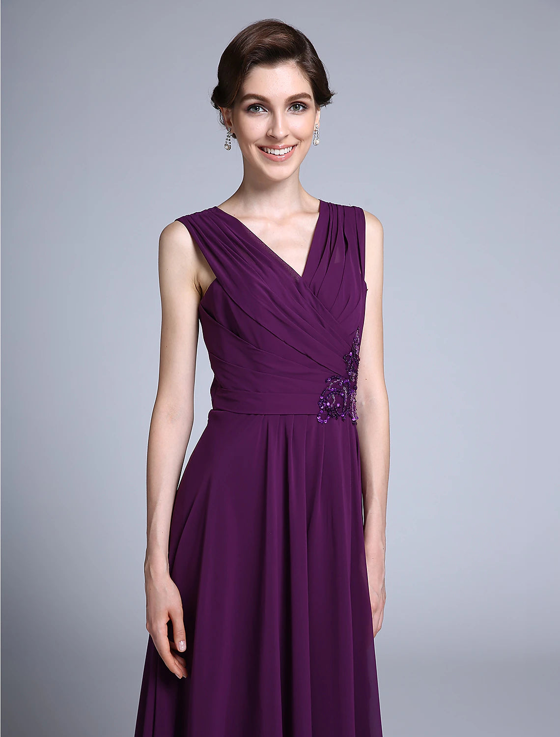 Woman posing gracefully in the sleeveless navy blue formal dress.