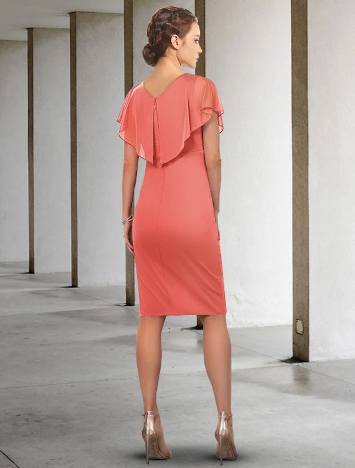 Back view of a woman in a ruched chiffon knee-length Mother of the Bride dress.