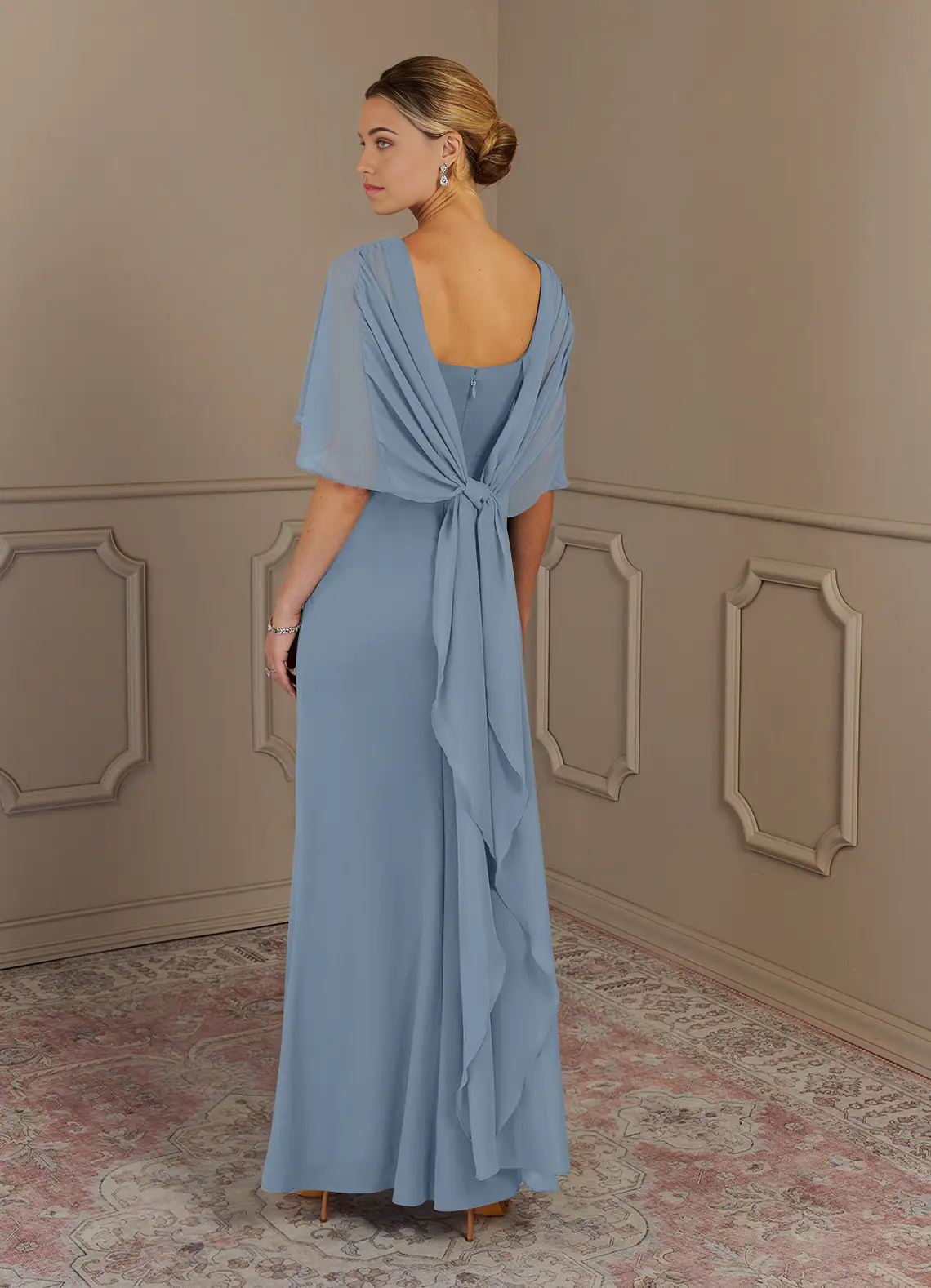 Side view of a model in a dusty blue V-neck evening gown.