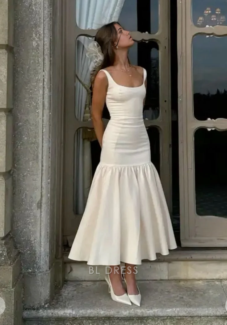 Woman wearing an elegant white V-neck sleeveless sheath dress.