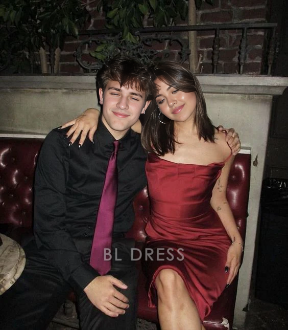 Woman wearing a short burgundy sheath dress with spaghetti straps.