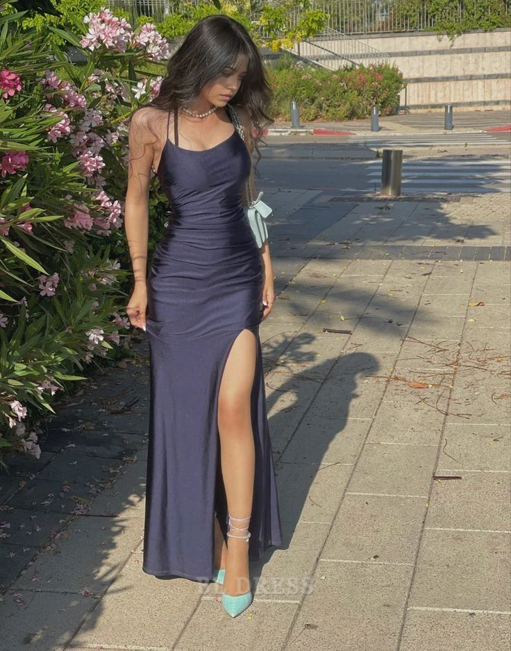 Model wearing a navy blue sheath long formal dress with spaghetti straps and a side slit.