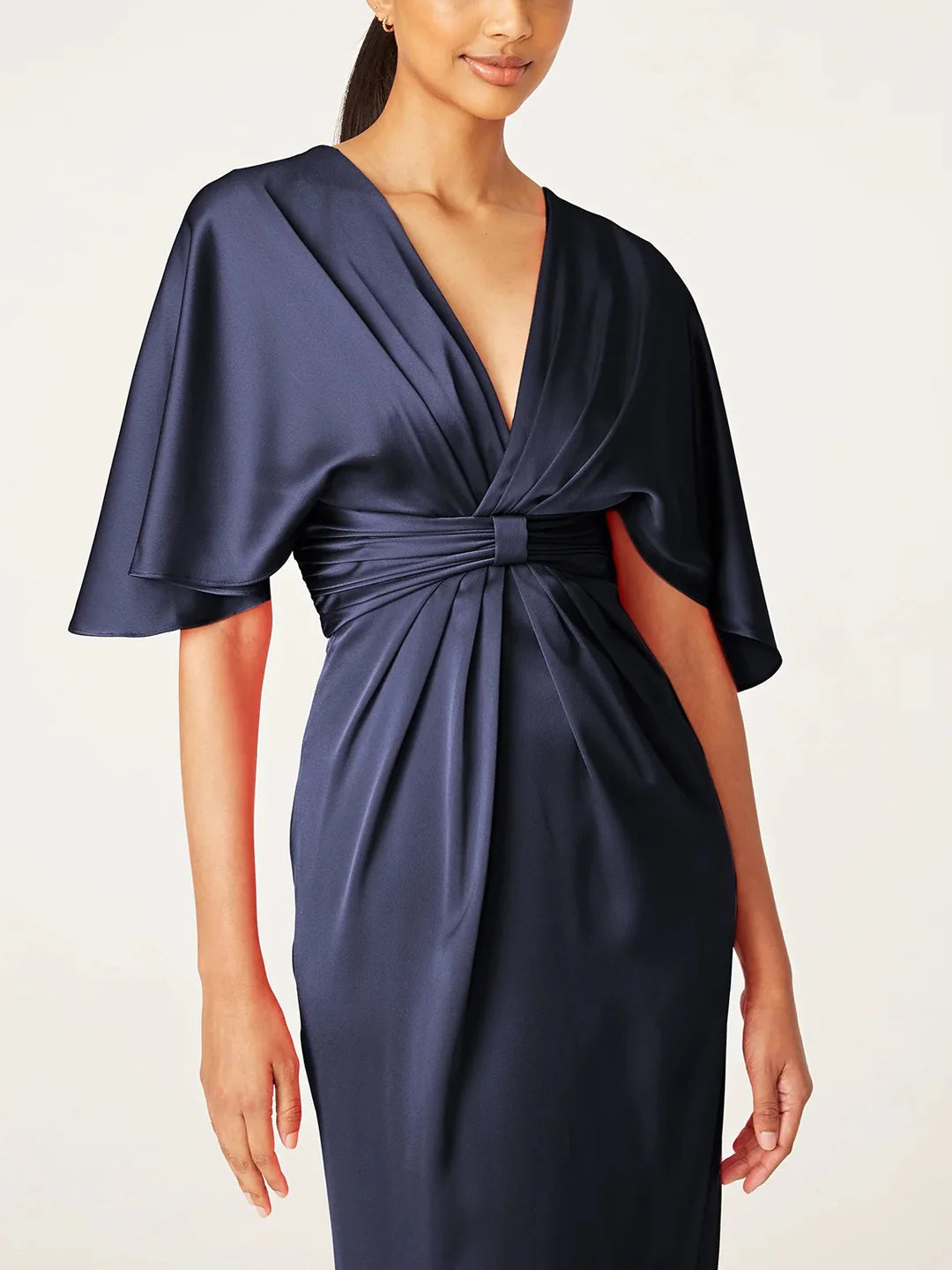 Side profile of the V-neck sheath dress, showcasing its tea length.