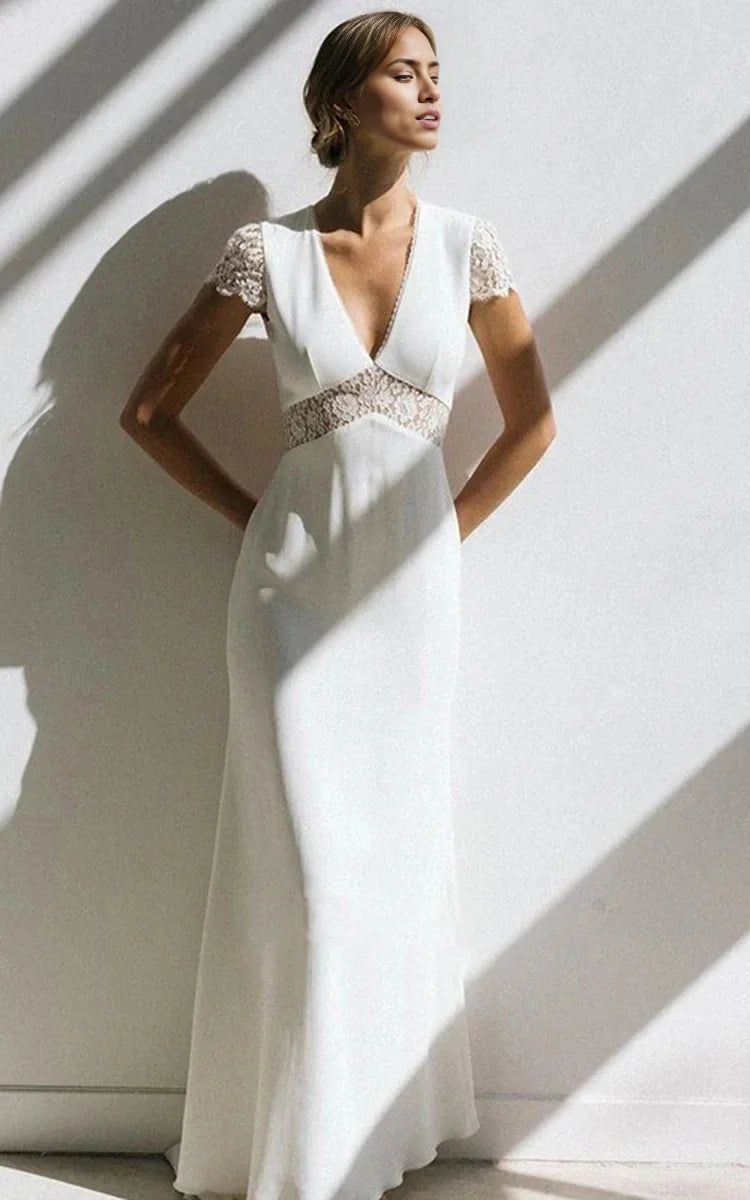 Model wearing an elegant white sheath V-neck short sleeve chiffon wedding dress with a sweep train.