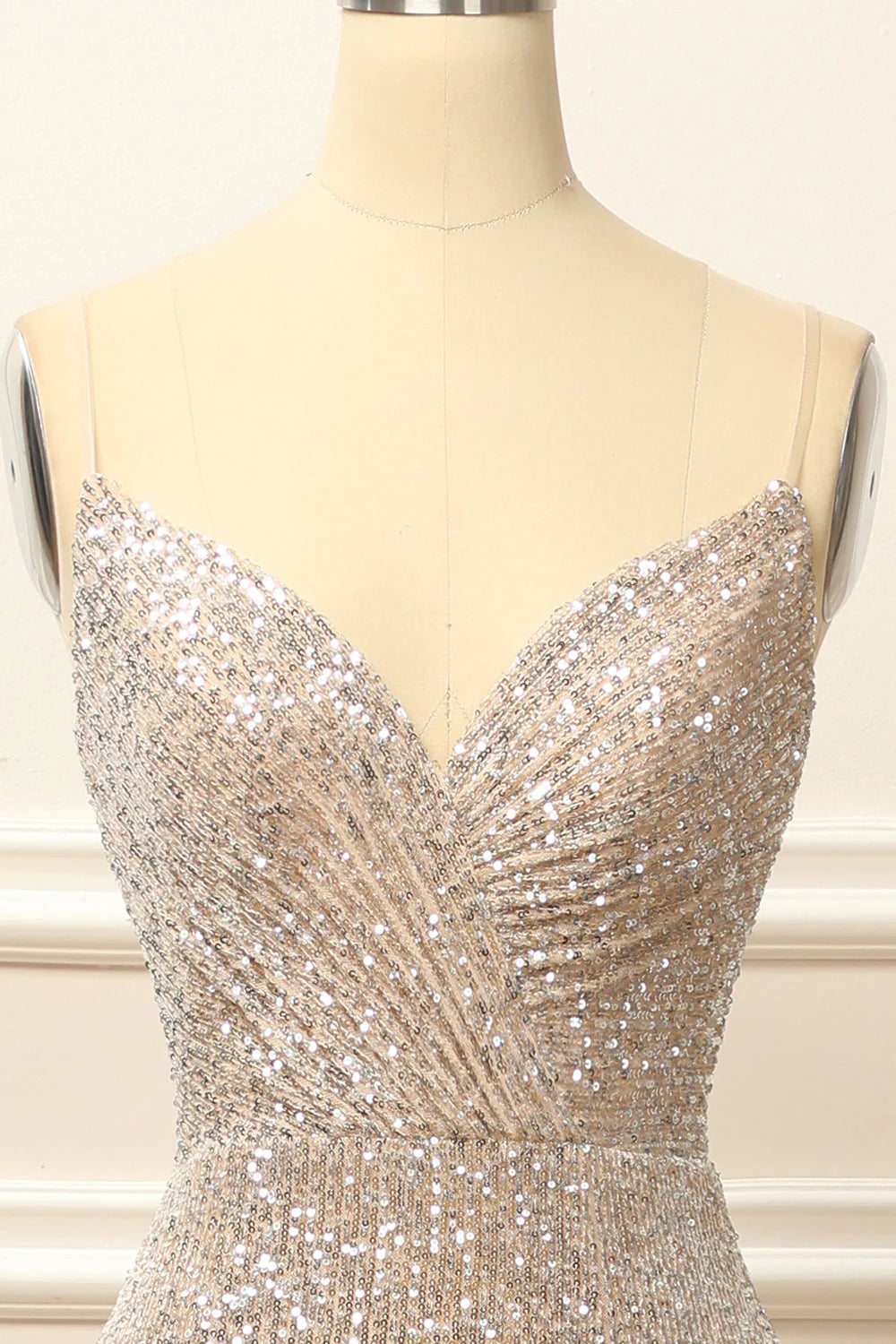 Close-up of the intricate silver sequin fabric and V-neckline of the dress.