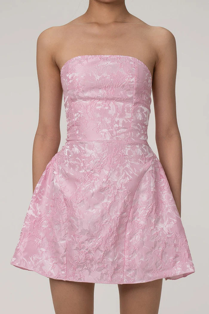 Model wearing a silky satin strapless floral jacquard mini dress.
