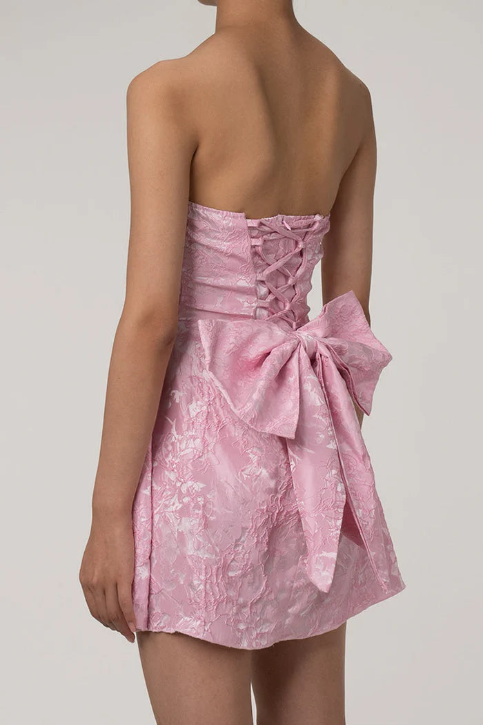 Close-up of the laced back with bow trim on the mini dress.