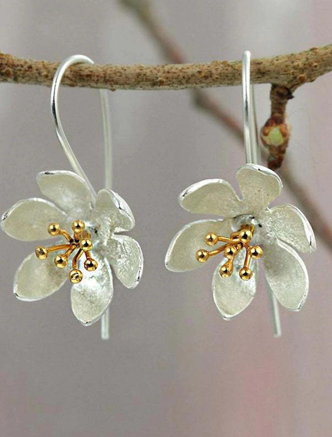 Pair of silver flower hoop earrings displayed elegantly.