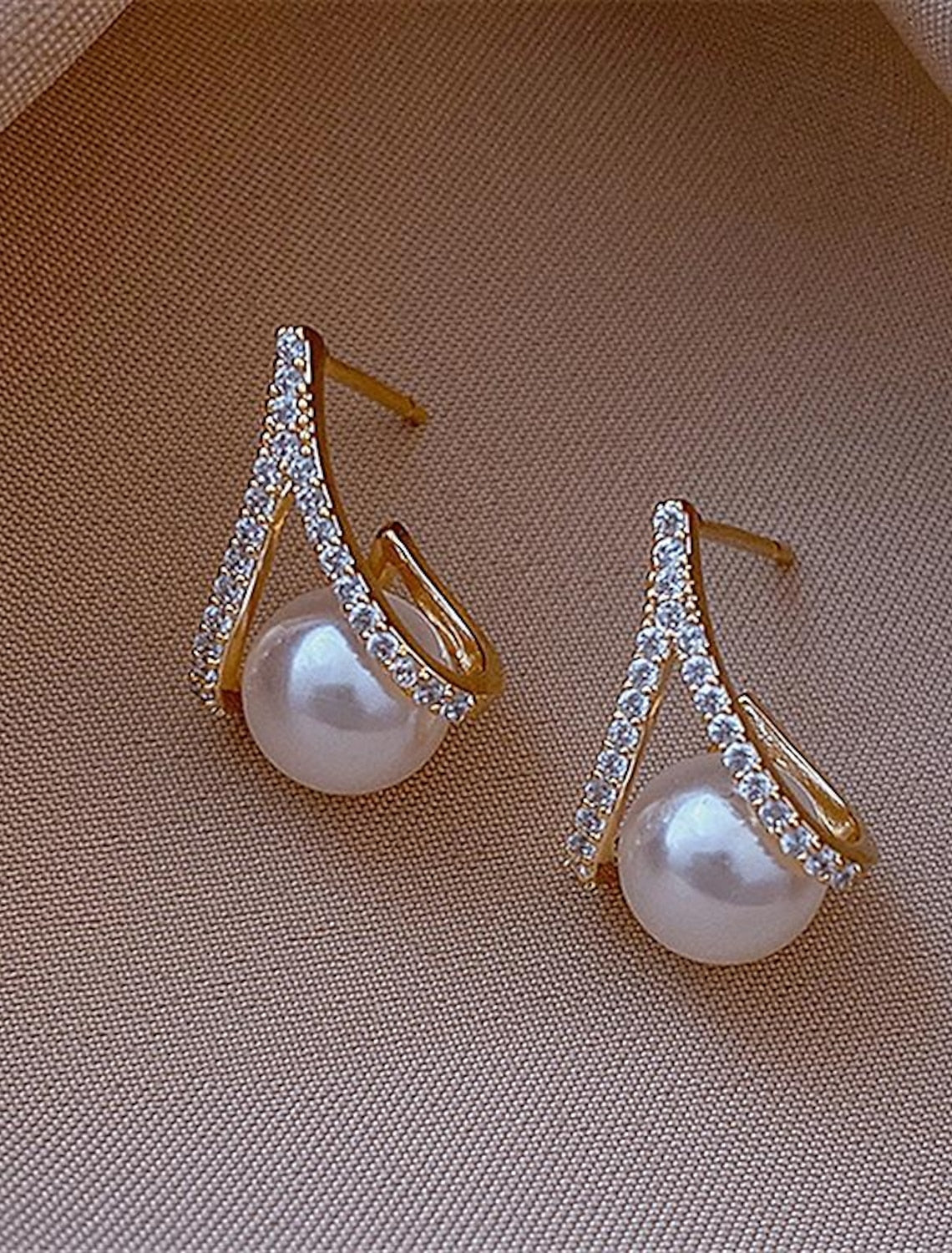 Pair of silver pearl stud earrings displayed on a white surface.