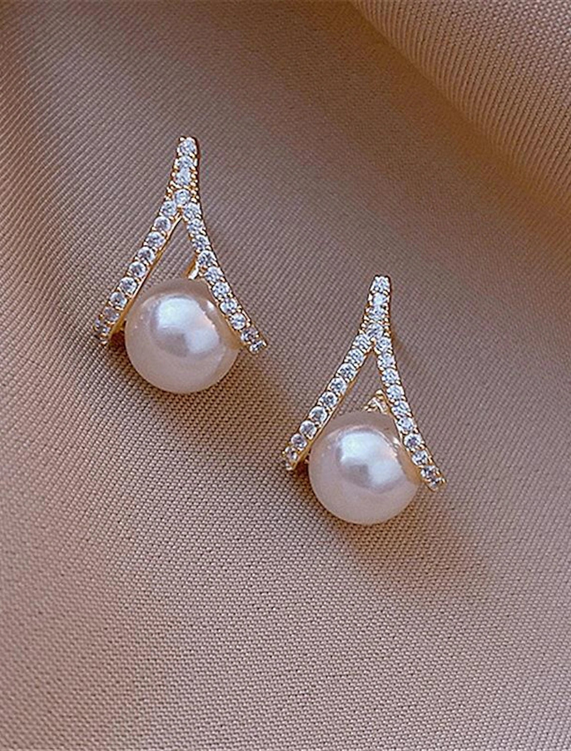 Woman wearing elegant silver pearl stud earrings, side profile.