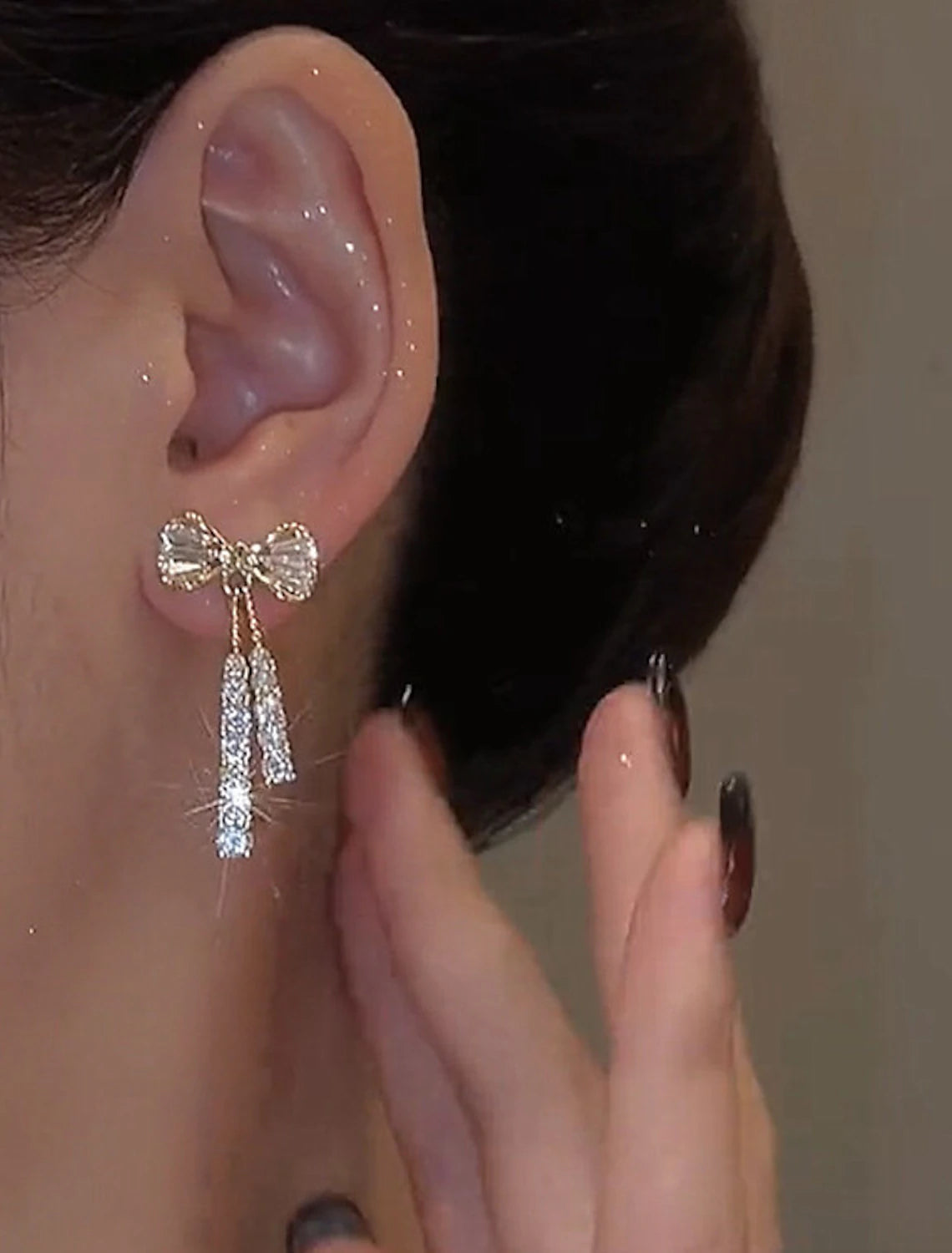 Close-up of an elegant silver zircon bowknot drop earring.