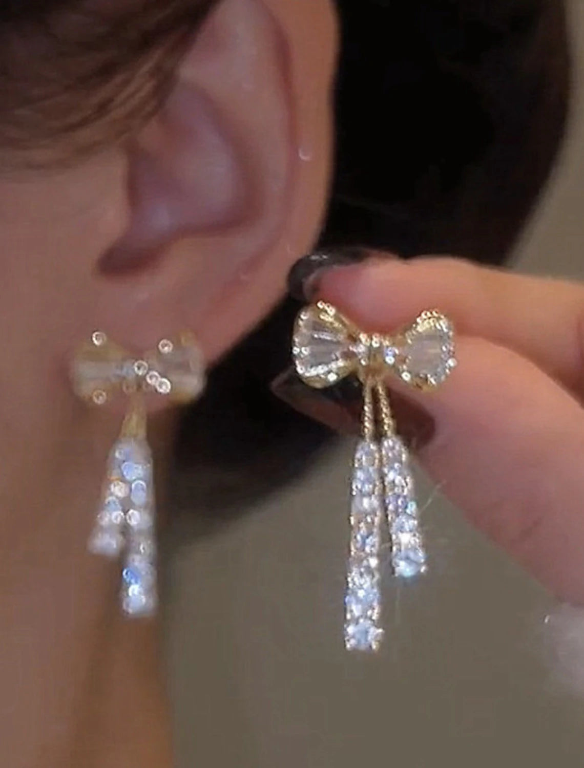 Model wearing silver zircon bowknot drop earrings.