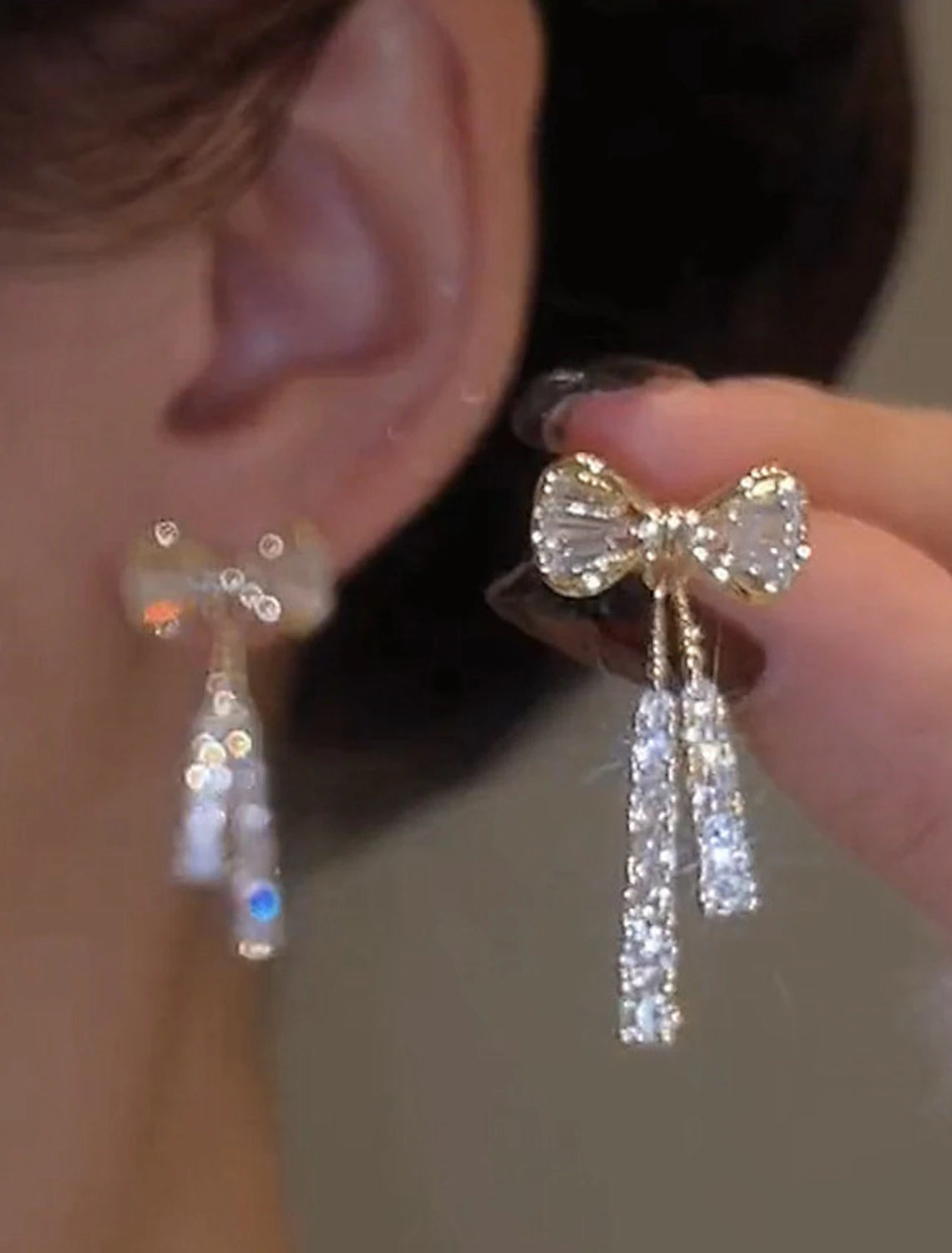 Detailed view of the zircon and bowknot design on a silver earring.