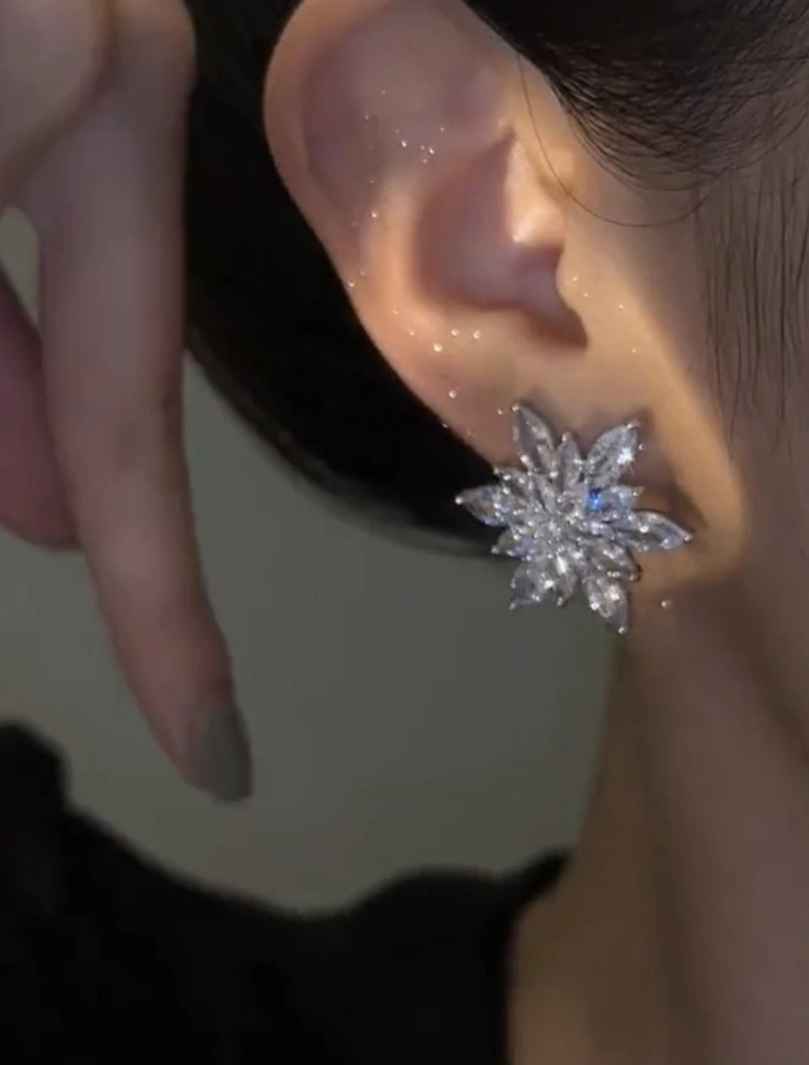 Close-up of silver zircon flower stud earrings.
