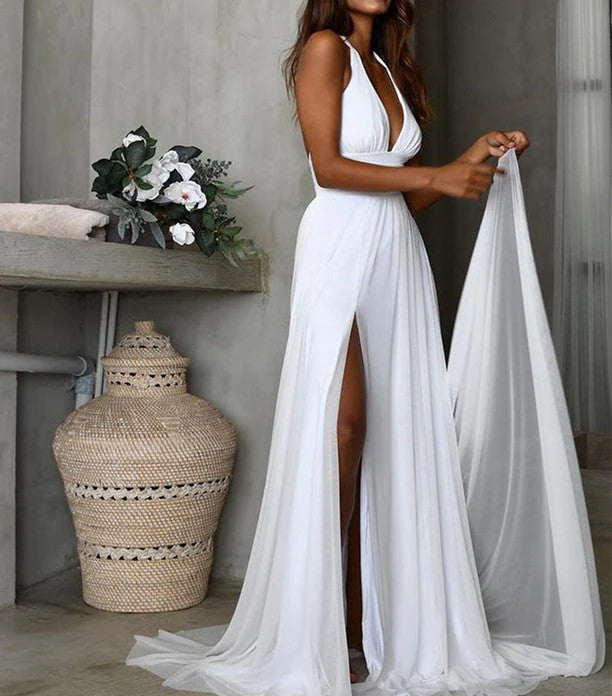 Woman wearing an elegant white V-neck A-line chiffon wedding dress on a beach.