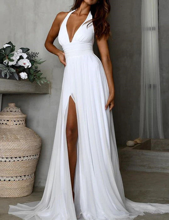 Back view of a woman in a simple white chiffon beach wedding dress.