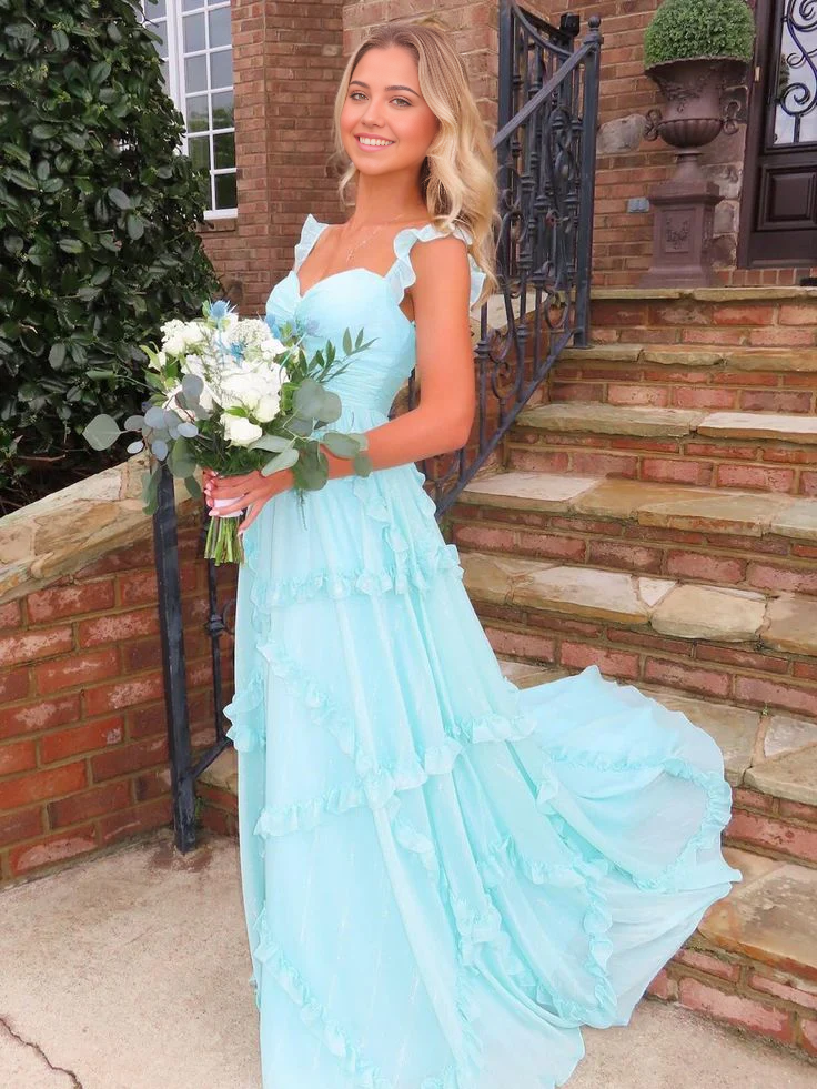Model wearing an elegant sky blue A-line formal dress with delicate straps and ruffles.