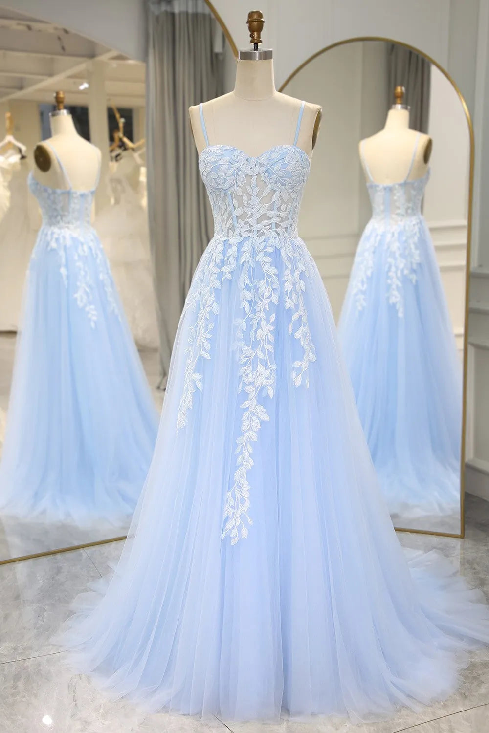 Model wearing a long sky blue mermaid prom dress with appliques and spaghetti straps.