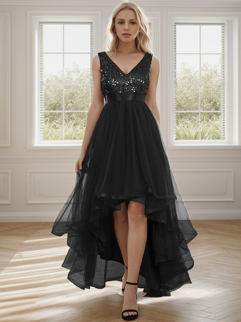 Woman wearing a sleeveless black sequin tulle high-low evening gown.