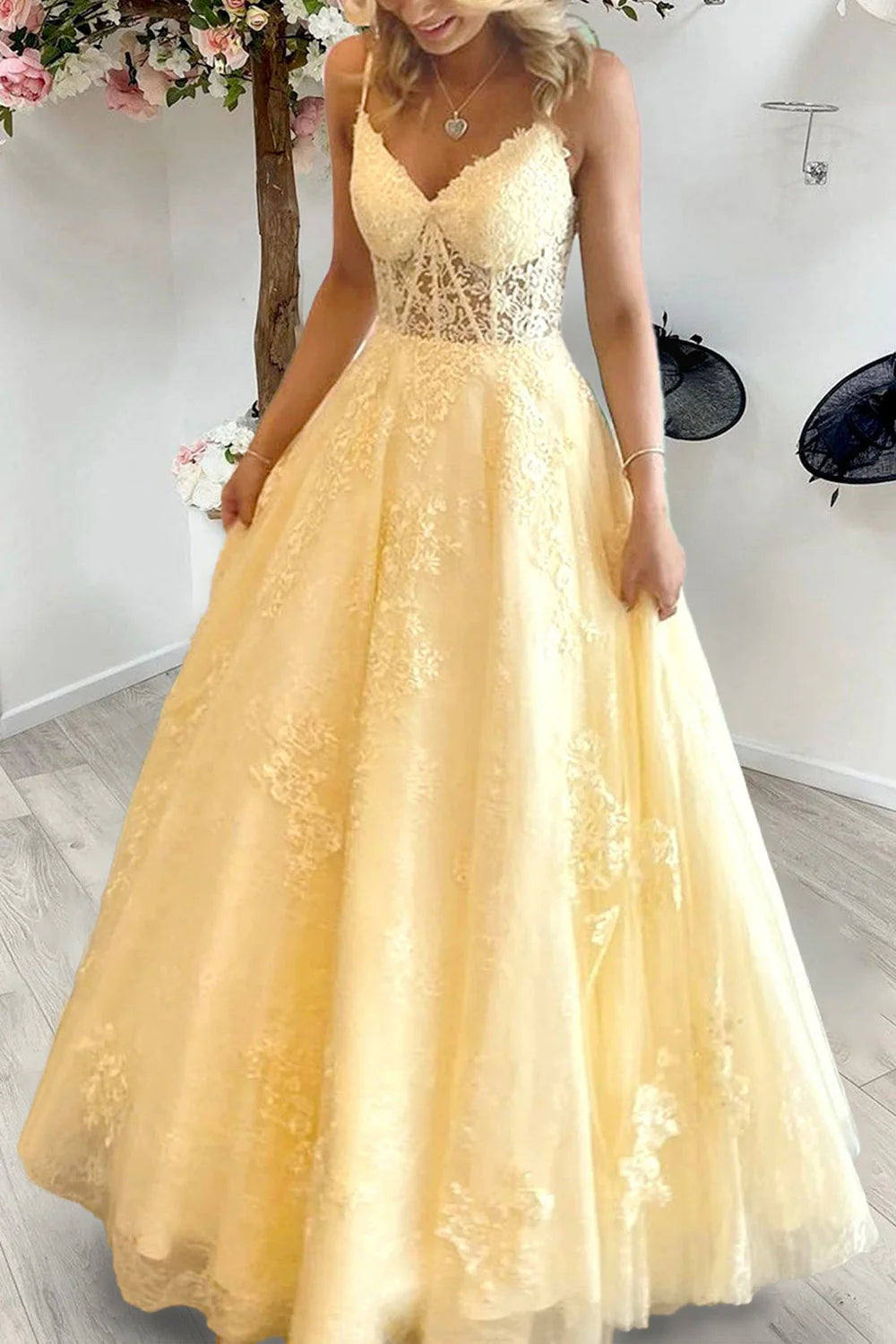 Elegant long prom dress with spaghetti straps, appliques, and a corset bodice.