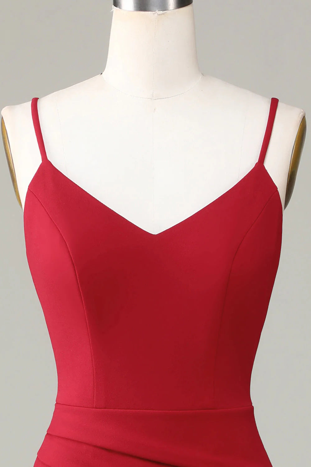 Back view of a woman wearing a spaghetti strap formal dress, highlighting the elegant silhouette.