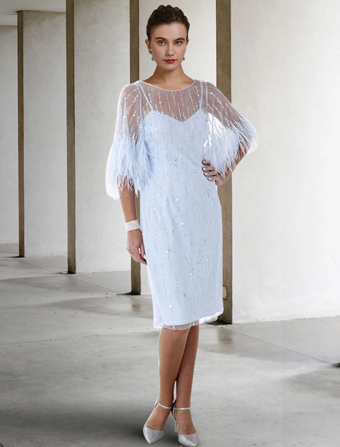 Elegant knee-length sheath dress with jewel neck and half sleeves, featuring sparkle and shine.
