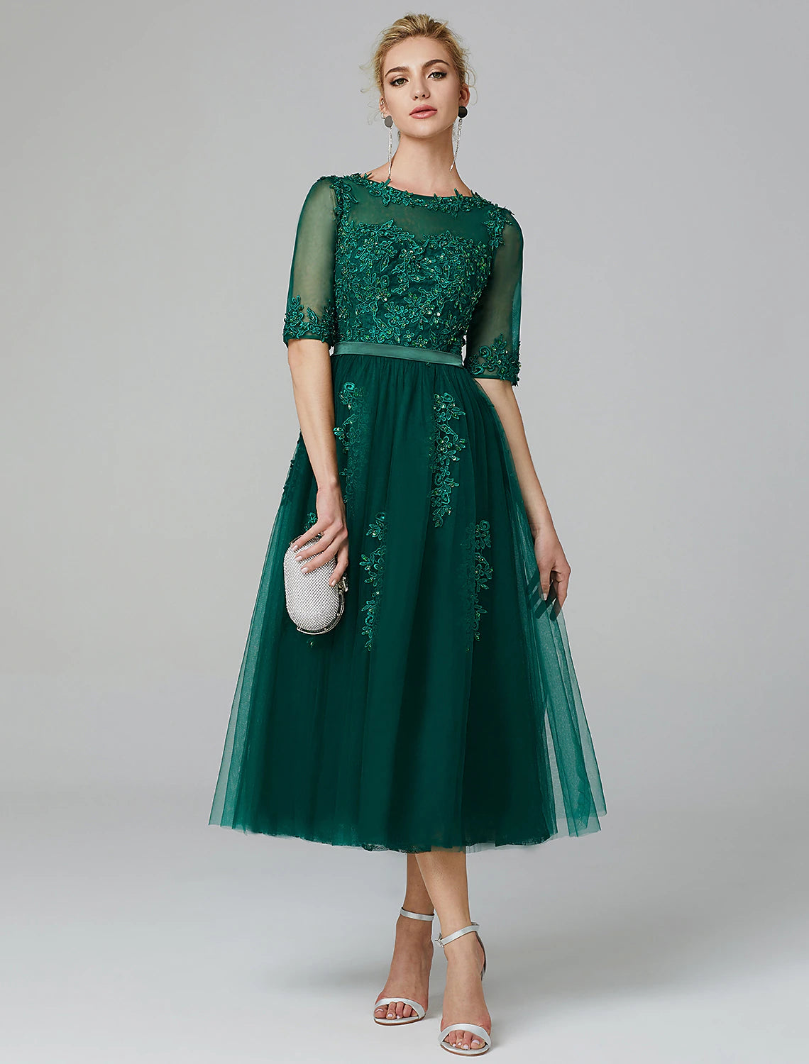 Elegant A-line tea length dress with illusion neck and sequin lace.