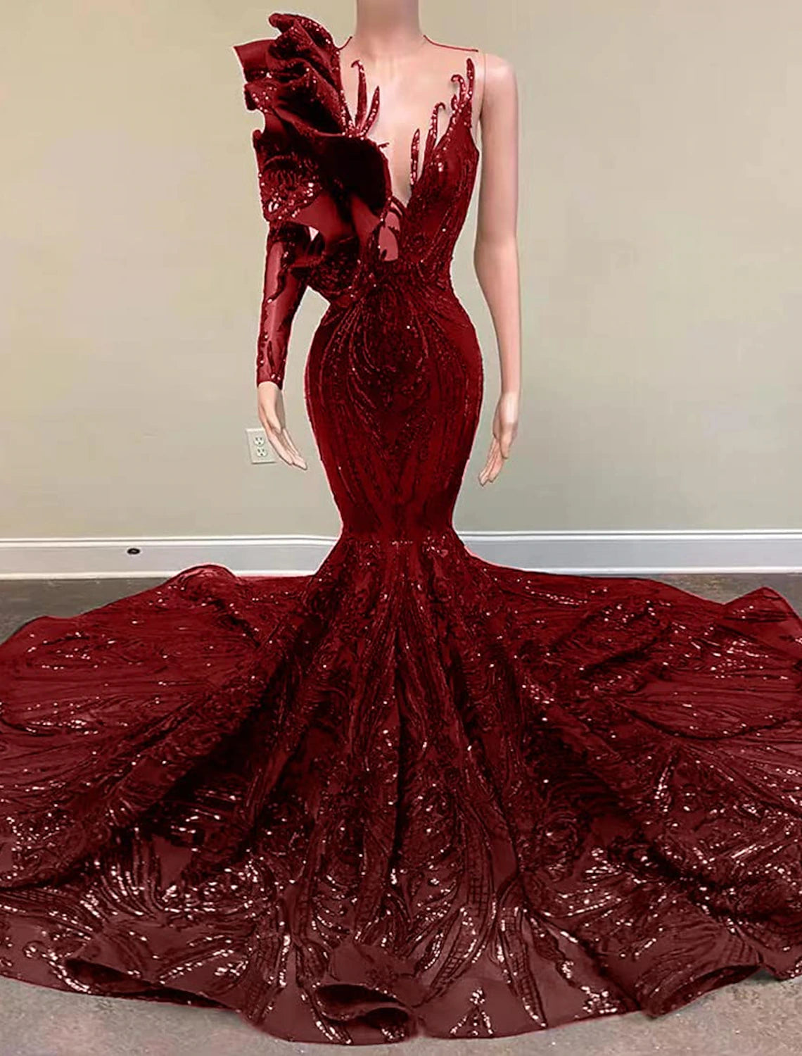 Side view of the model in the one-shoulder long sleeve sequined gown.