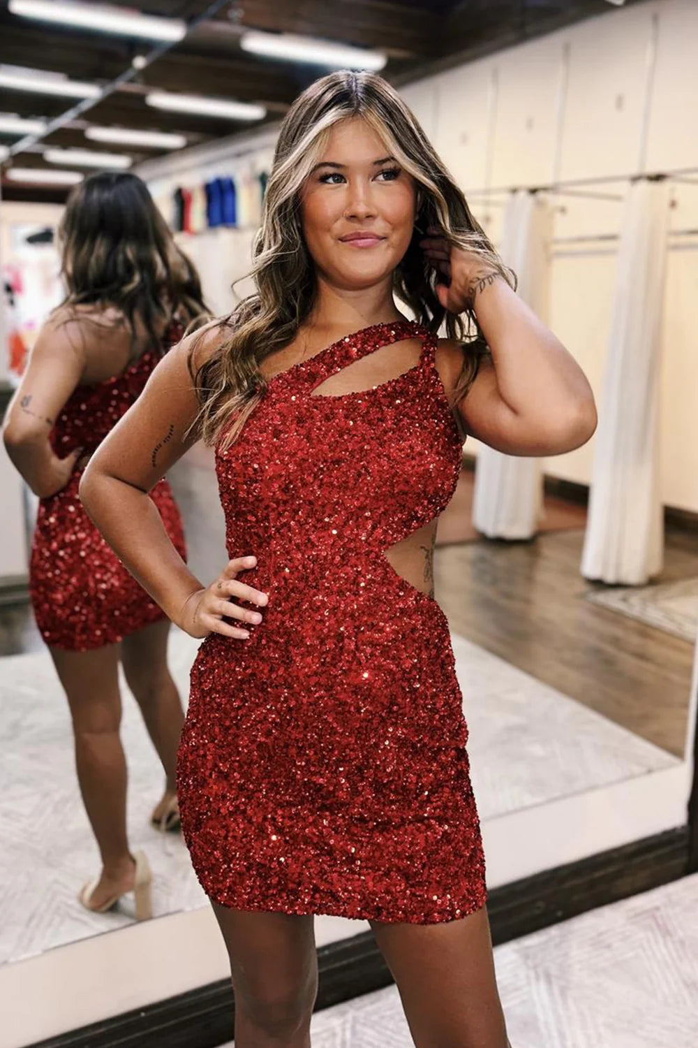 Back view of a red sparkly one-shoulder short prom dress.
