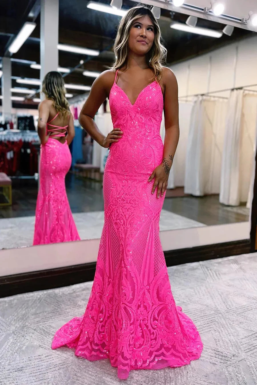 Woman wearing a sparkly V-neck mermaid prom dress.