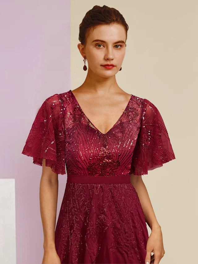 Side view of a woman wearing the floor-length sequined Mother of the Bride dress.