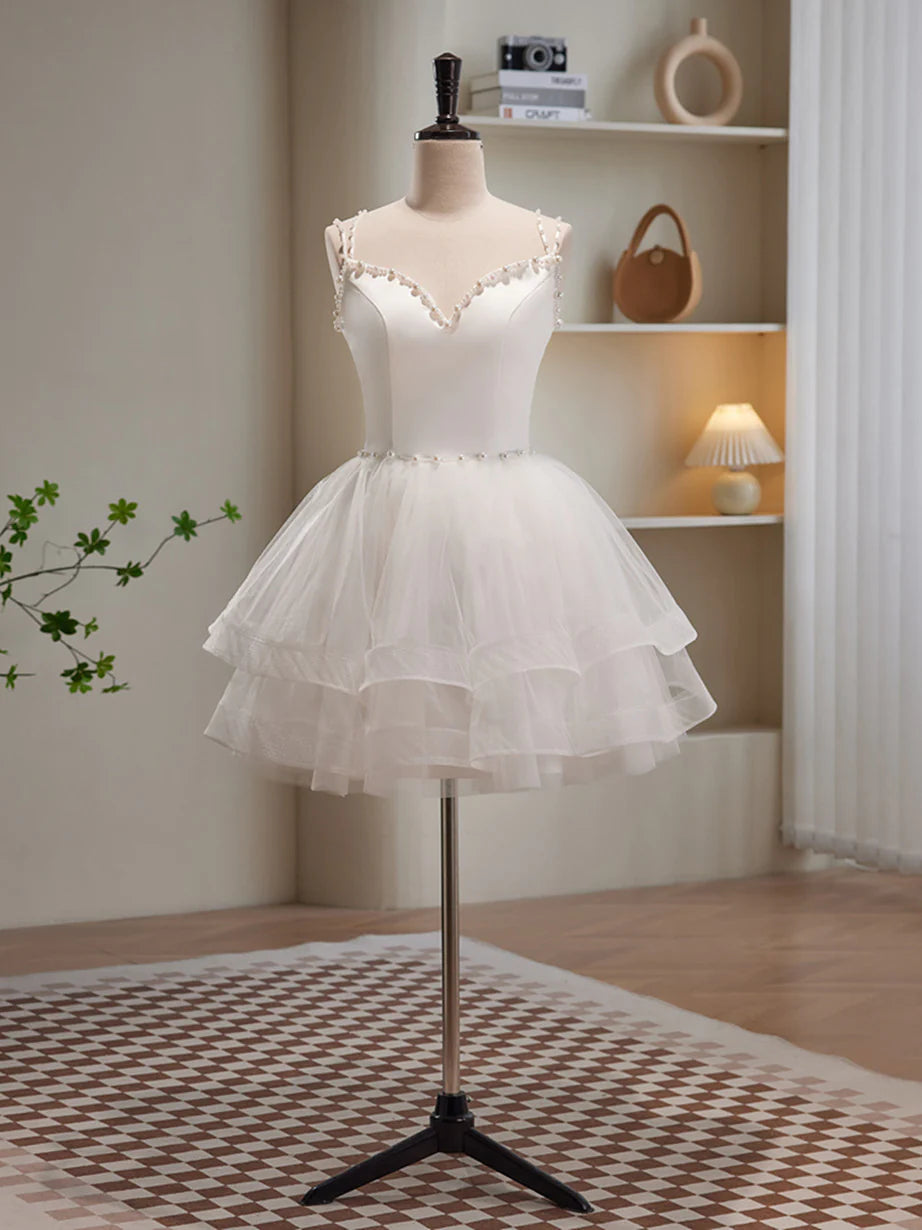 Model wearing an elegant white short tulle dress with beading, front view.