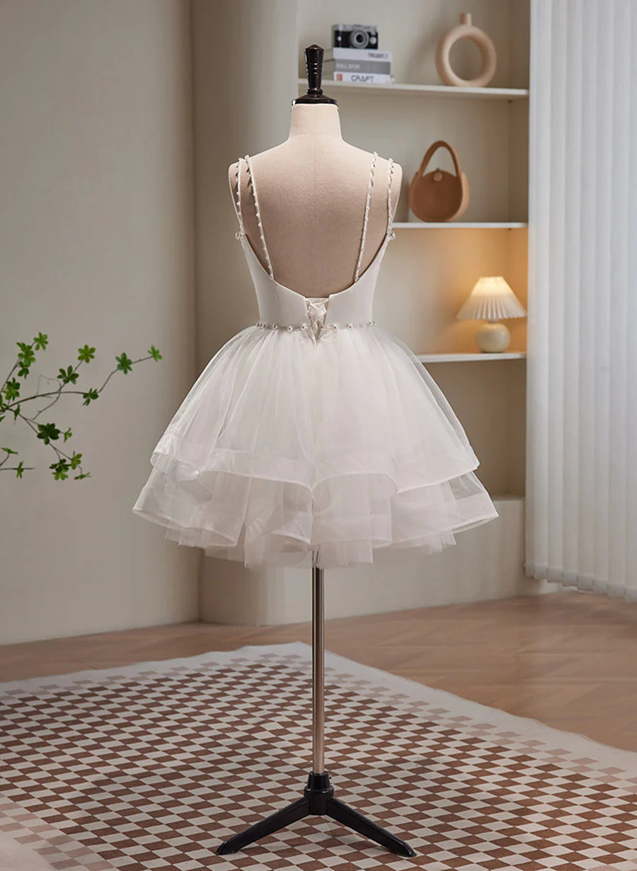 Back view of a white short graduation dress featuring a tulle skirt and beaded bodice.