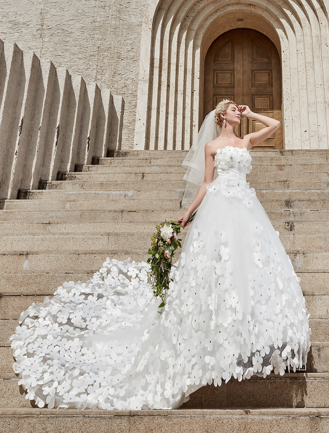 Elegant strapless ball gown wedding dress with square neck and lace details.