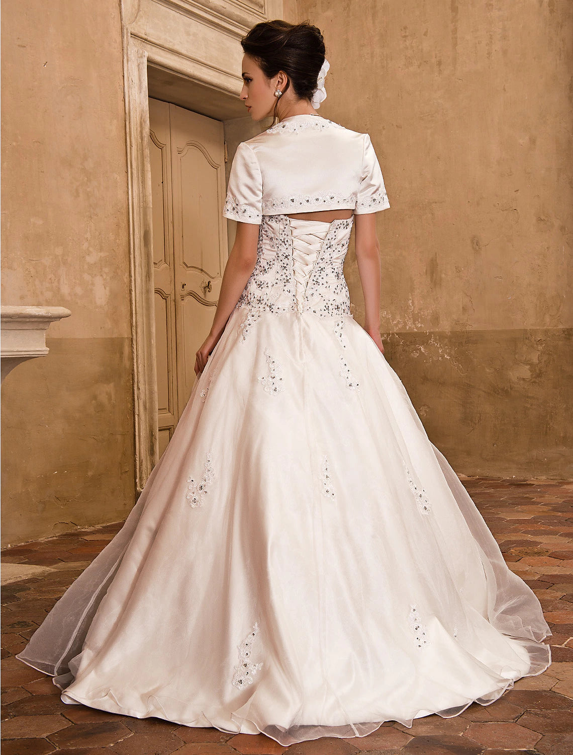 Close-up of beading and appliques on a satin wedding dress bodice.