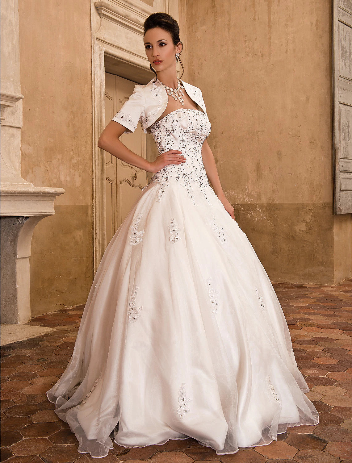 Side profile of a strapless bridal ball gown with flowing satin fabric.