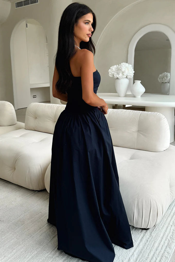 Full length view of a woman posing in a navy blue strapless A-line gown.