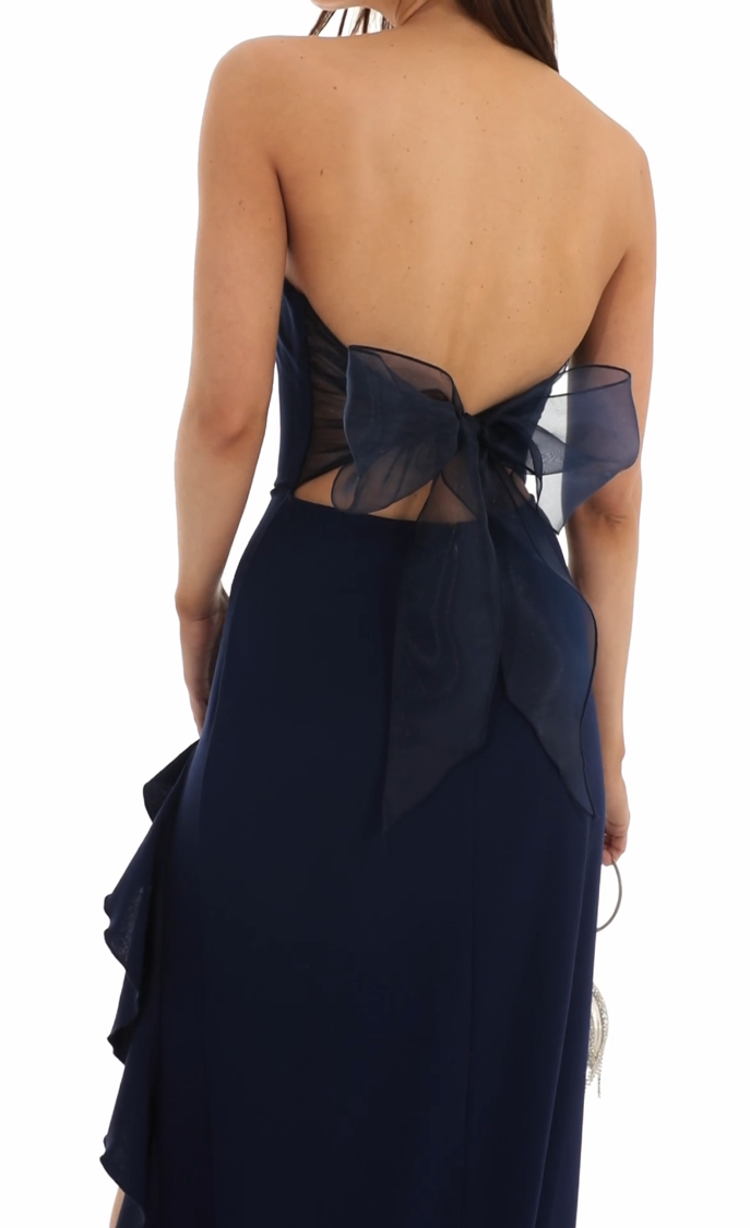 Side profile of a woman in a navy strapless formal gown.
