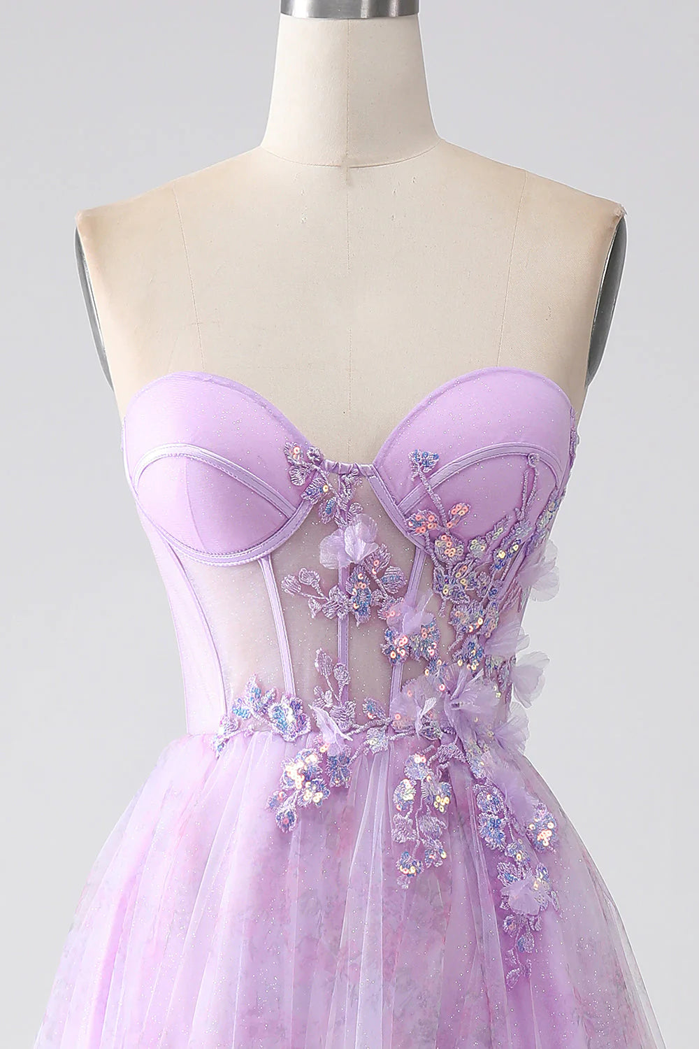 Side profile of a model wearing a purple strapless prom dress.