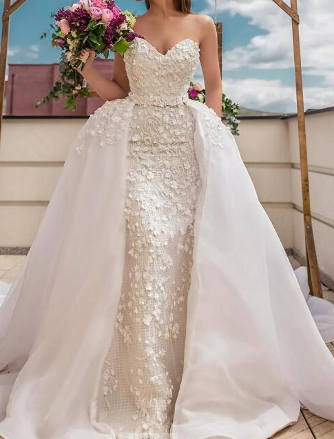 Elegant strapless lace ball gown wedding dress worn by a model, showcasing its floor-length design and intricate lace.