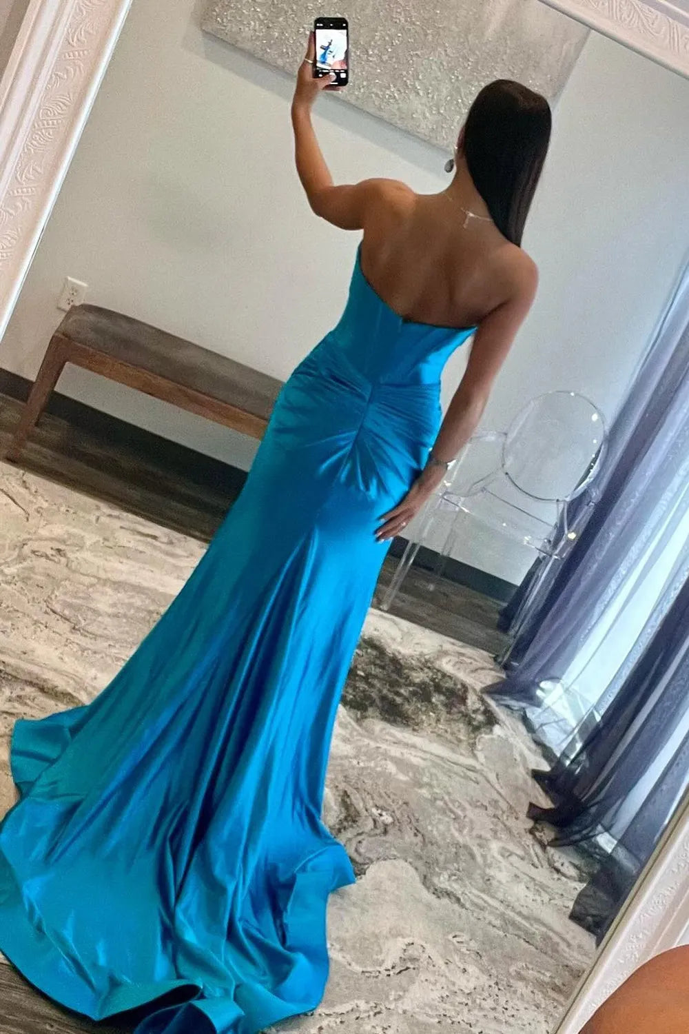 Back view of a woman wearing the strapless mermaid satin prom dress.