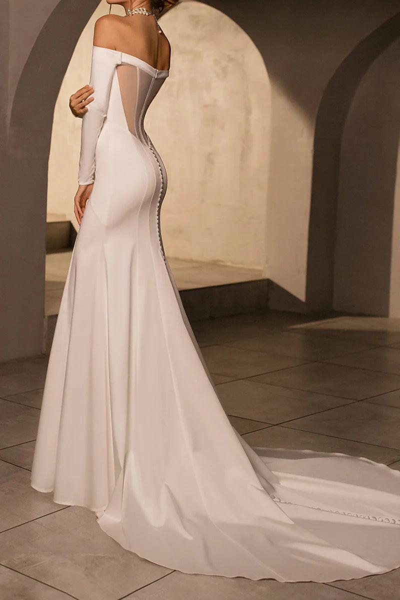 Side view of a bride in a strapless mermaid satin wedding gown.