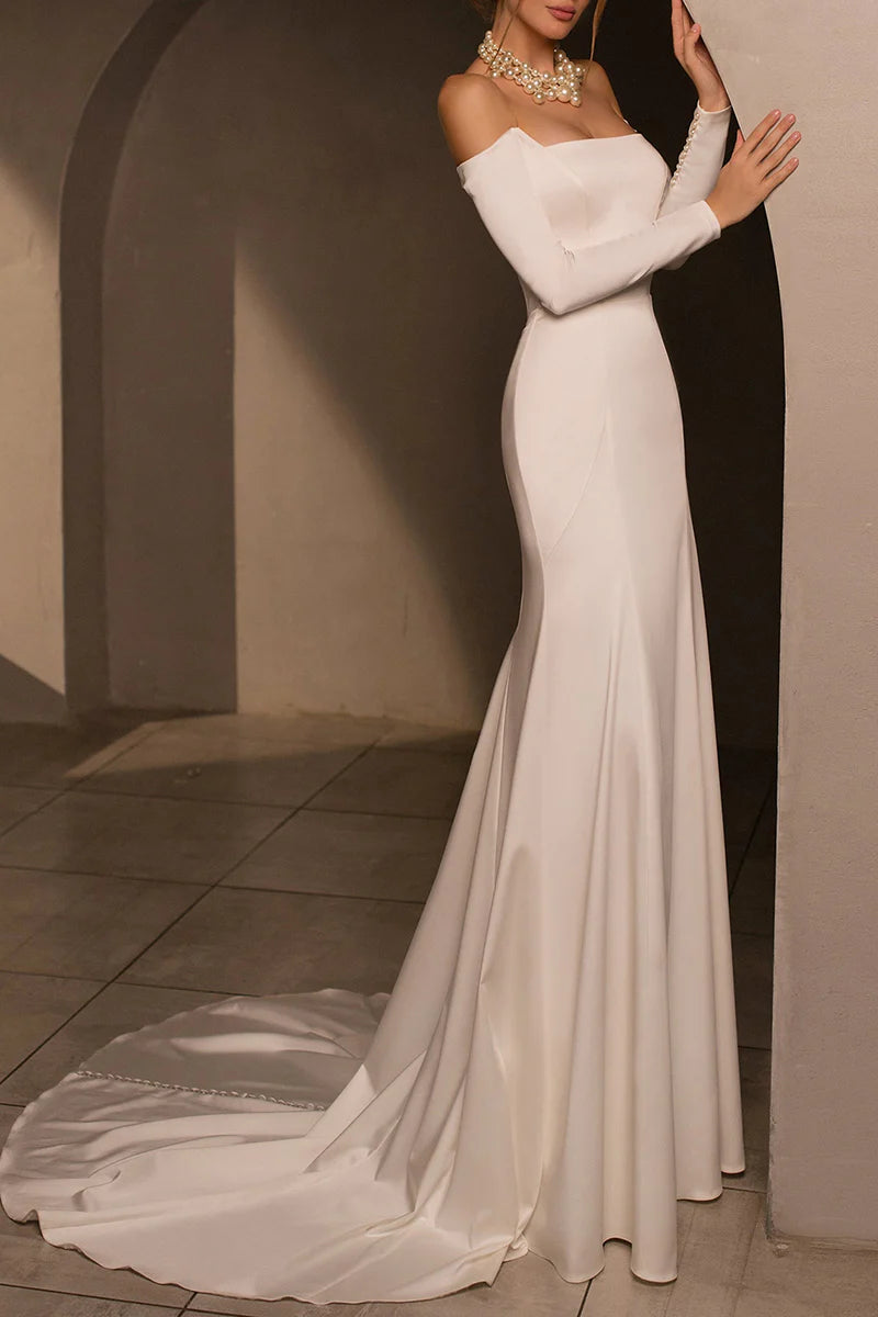 Bride posing in a fitted strapless mermaid wedding dress.