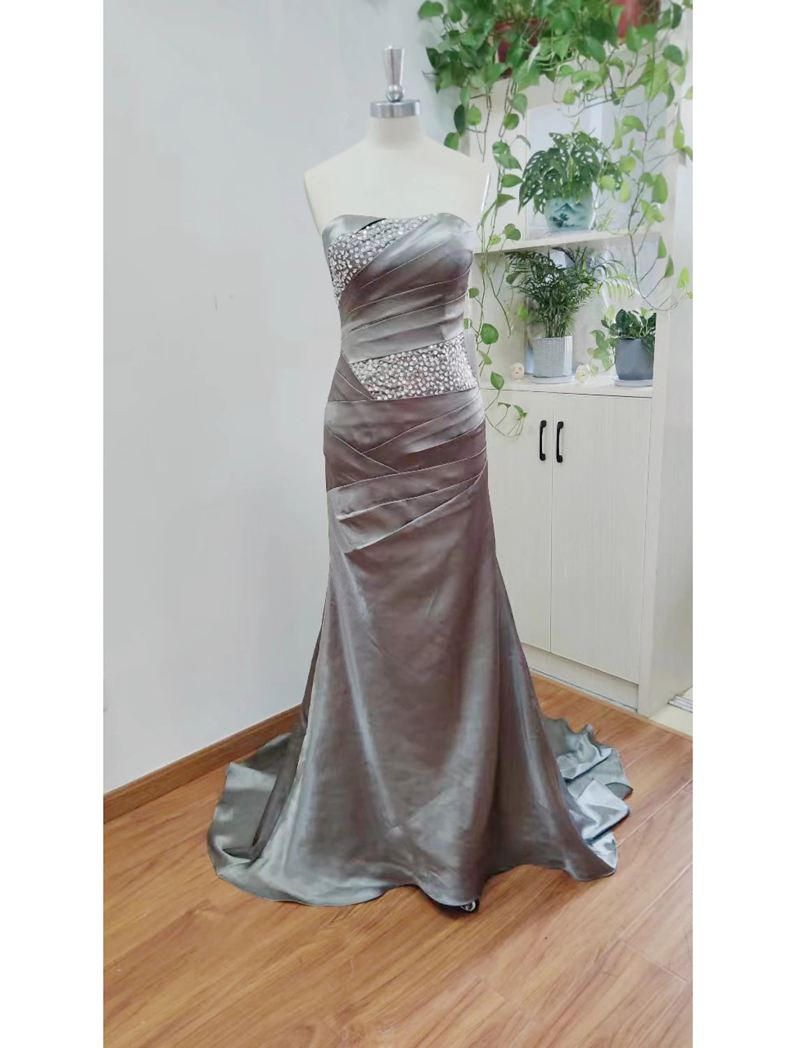 A woman wearing the strapless mermaid trumpet evening dress, viewed from the side, highlighting the silhouette and train.