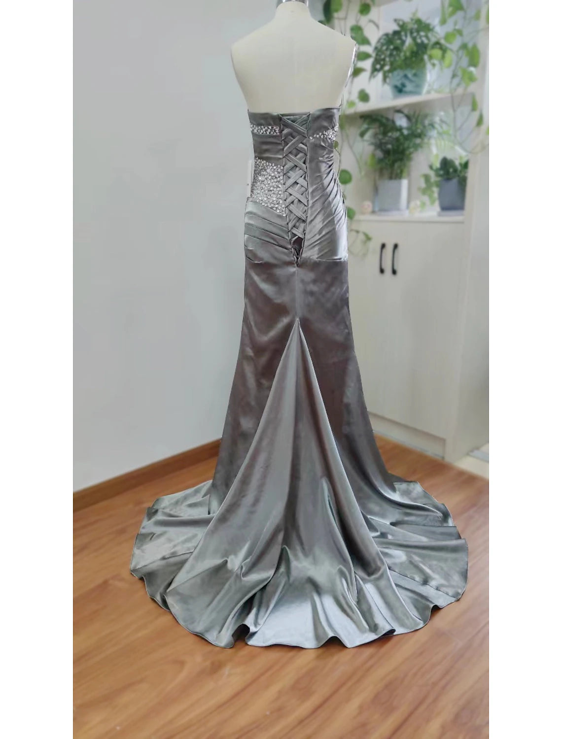 A woman wearing the strapless mermaid trumpet evening dress, posing elegantly, emphasizing the sparkling fabric.
