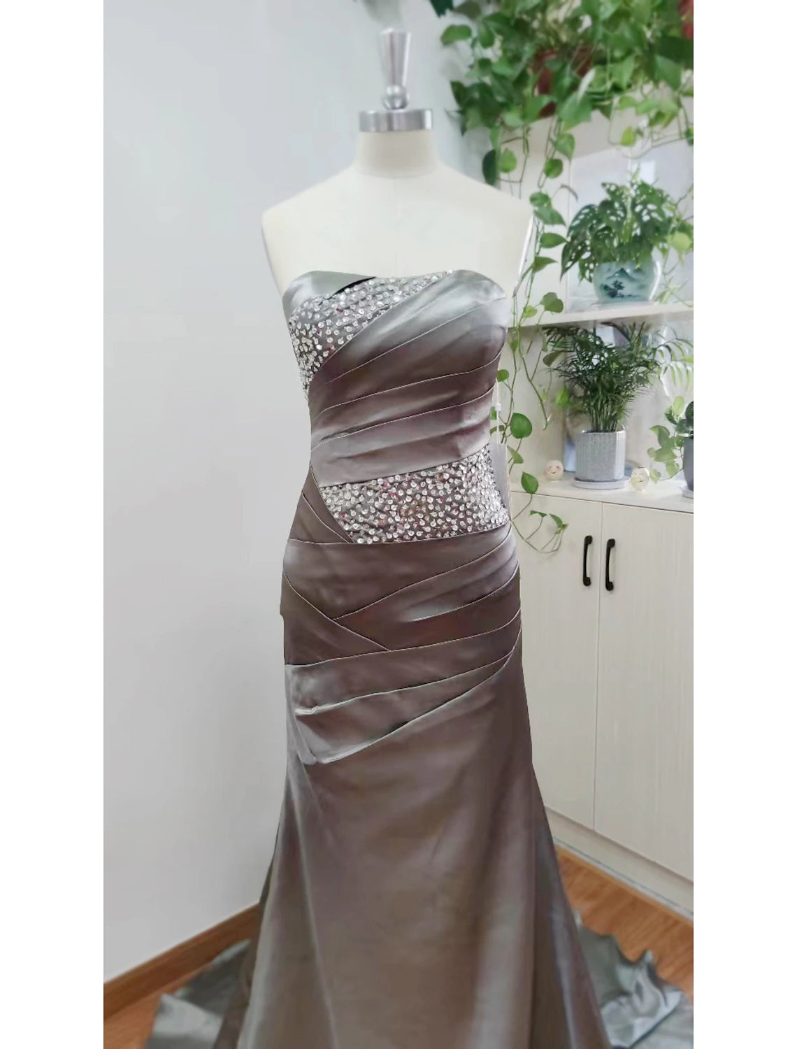 A woman wearing the strapless mermaid trumpet evening dress, showcasing the full length and elegant drape.